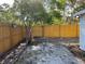 Fenced backyard featuring a sandy area, bordered by mulch and a wooden fence at 1700 Hollywood Ave, Eustis, FL 32726