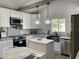 Bright kitchen showcasing stainless steel appliances, marble countertops, and white cabinets at 1700 Hollywood Ave, Eustis, FL 32726