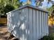 View of white metal outdoor storage shed with a slightly sloped roof in the backyard at 1700 Hollywood Ave, Eustis, FL 32726