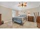 Cozy bedroom showcasing a decorative ceiling fan, tiled floors, neutral paint, and stylish furnishings at 17126 Se 78Th Larchmont Ct, The Villages, FL 32162