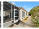 Back of home showing screened-in patio with sliding door entrance; landscaped walkway on side of house at 17126 Se 78Th Larchmont Ct, The Villages, FL 32162