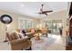 Comfortable living room with ceiling fan, tile flooring, and sliding glass doors that lead to the patio at 17126 Se 78Th Larchmont Ct, The Villages, FL 32162