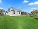 Rear view of a home with lush green lawn and screened patio at 17635 Se 82Nd Annadale Ter, The Villages, FL 32162