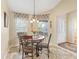 Cozy dining area with a round table, decorative chairs, and bright windows with floral accents at 17635 Se 82Nd Annadale Ter, The Villages, FL 32162