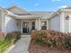 Charming home entrance featuring a welcoming front door, cozy seating, and vibrant landscaping at 17635 Se 82Nd Annadale Ter, The Villages, FL 32162