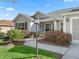 Inviting home entrance with a well-maintained walkway, mature landscaping, and a charming front door at 17635 Se 82Nd Annadale Ter, The Villages, FL 32162