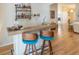 Close-up of a wooden bar with blue chairs, wooden floors, and a fully stocked bar shelf at 1828 Augustine Dr, The Villages, FL 32159