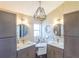 Stylish bathroom features dual sinks with granite counters, decorative lighting, and a central makeup table at 1828 Augustine Dr, The Villages, FL 32159