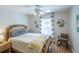 Cozy bedroom featuring a decorative bed frame, ceiling fan, and natural light from the window at 1828 Augustine Dr, The Villages, FL 32159