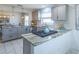 Modern kitchen featuring gray cabinets, marble countertops, and white tile flooring at 1828 Augustine Dr, The Villages, FL 32159