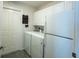 Functional laundry room with white washer, dryer, and a white refrigerator at 1828 Augustine Dr, The Villages, FL 32159