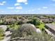 A high-angle shot of a neighborhood with lush greenery, well-maintained lawns, and tiled roofs at 2031 Capri Ln, Mount Dora, FL 32757