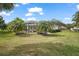 Lush backyard showcases a screened-in pool area and lush green lawn at 2031 Capri Ln, Mount Dora, FL 32757