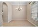 Elegant dining room featuring tile flooring, a chandelier, and a large window for natural light at 2031 Capri Ln, Mount Dora, FL 32757