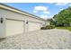 Spacious three-car garage with a paved driveway and manicured landscaping for enhanced curb appeal at 2031 Capri Ln, Mount Dora, FL 32757