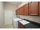 Functional laundry room features wooden cabinets, sink, washer and dryer at 2031 Capri Ln, Mount Dora, FL 32757