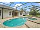 Inviting screened-in pool area with hot tub and lush green landscaping at 2031 Capri Ln, Mount Dora, FL 32757