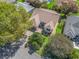 Aerial view of a beautifully landscaped home with green grass and many trees at 2039 Palo Alto Ave, The Villages, FL 32159