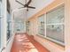 Enclosed Florida room with a ceiling fan, orange painted concrete floor, and many windows at 2039 Palo Alto Ave, The Villages, FL 32159