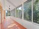 Enclosed sunroom with many windows and an orange painted concrete floor at 2039 Palo Alto Ave, The Villages, FL 32159