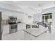 Open-concept kitchen showcasing stainless steel appliances, white cabinetry, and a breakfast nook with natural light at 2039 Palo Alto Ave, The Villages, FL 32159