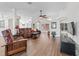 Open-concept living room with hardwood floors, ceiling fan, and large windows at 2039 Palo Alto Ave, The Villages, FL 32159