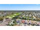 A broad aerial view of a neighborhood, revealing a golf course and lake amidst the residences at 2058 Thornton Ter, The Villages, FL 32162