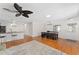 Open floor plan with bar seating, and dark modern cabinets with hardwood floors leading to the dining area at 2058 Thornton Ter, The Villages, FL 32162