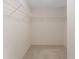 An empty walk-in closet with shelving and neutral carpet at 2058 Thornton Ter, The Villages, FL 32162