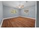 Bedroom with wood floors, neutral paint, and several windows that provide natural light at 211 Sara Ln, Leesburg, FL 34748