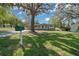 Quaint home featuring a lush green lawn and a classic mailbox, nestled under an expansive shaded tree at 211 Sara Ln, Leesburg, FL 34748