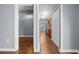 Hallway view showing closet storage and kitchen with wood floors, stainless appliances, and pantry in the distance at 211 Sara Ln, Leesburg, FL 34748