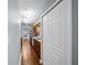 Hallway view of the kitchen featuring stainless appliances, wood cabinets, and ample storage in the pantry down the hall at 211 Sara Ln, Leesburg, FL 34748