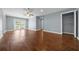 Bright living room featuring wood floors, neutral walls, French doors, and access to hallway and closet at 211 Sara Ln, Leesburg, FL 34748