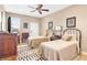 Bedroom with twin beds, ceiling fan, artwork, and a vintage rug, offering a cozy space at 220 Nautica Mile Dr, Clermont, FL 34711