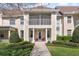 Beautiful townhome exterior showcasing a covered porch, second-story balcony, manicured lawn, and attractive landscaping at 220 Nautica Mile Dr, Clermont, FL 34711