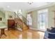 Inviting foyer with hardwood floors, staircase, decorative window treatment, and a glass-paneled front door at 220 Nautica Mile Dr, Clermont, FL 34711