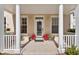 Charming front porch enhanced with tiled flooring, decorative columns, plants, and beautiful glass front door at 220 Nautica Mile Dr, Clermont, FL 34711