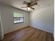 This is an empty bedroom that includes a window and wood floors and a ceiling fan at 2309 Fairview Ct, Eustis, FL 32726