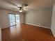 Bright living room with wood floors, ceiling fan, and sliding glass doors to the lanai at 2309 Fairview Ct, Eustis, FL 32726