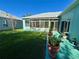 Inviting backyard featuring a screened-in porch, a well-manicured lawn, and potted plants on a painted patio at 25517 Laurel Valley Rd, Leesburg, FL 34748