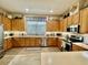 Well-lit kitchen featuring stainless steel appliances, ample wood cabinets, and laminate floors at 25517 Laurel Valley Rd, Leesburg, FL 34748