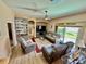 Spacious living room featuring cozy seating, built-in shelving, and sliding glass doors to the outdoors at 25517 Laurel Valley Rd, Leesburg, FL 34748