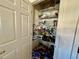 Walk-in pantry boasts wire shelving stocked with food items and household supplies for organized storage at 25517 Laurel Valley Rd, Leesburg, FL 34748