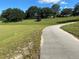 Scenic paved walking path with lush green space and neighborhood homes in the background at 25517 Laurel Valley Rd, Leesburg, FL 34748