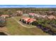 Aerial view of a beautiful home with a tile roof, nestled within a golf course community and scenic water views at 26207 Avenida Las Colinas # 13A, Howey In The Hills, FL 34737