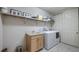 Bright laundry room featuring a sink, washer, dryer, white cabinets, and storage shelf at 26207 Avenida Las Colinas # 13A, Howey In The Hills, FL 34737