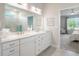 Bright bathroom featuring a double vanity, tile flooring, with a view into the bedroom at 26694 Otter Creek Ln, Leesburg, FL 34748