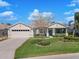 Charming single-story home with manicured lawn, lush landscaping, and a welcoming front porch at 26694 Otter Creek Ln, Leesburg, FL 34748