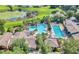 Aerial view of community pool, spa and clubhouse surrounded by palm trees and manicured grounds at 26694 Otter Creek Ln, Leesburg, FL 34748